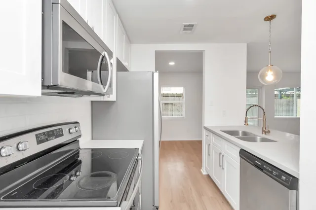 a kitchen with a sink stove and cabinets