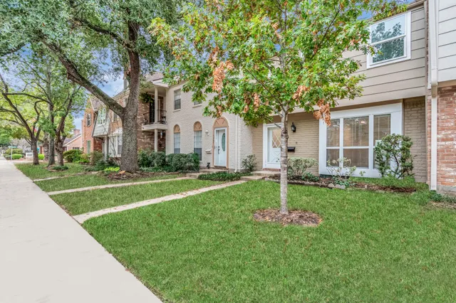 a house with a big yard and large trees