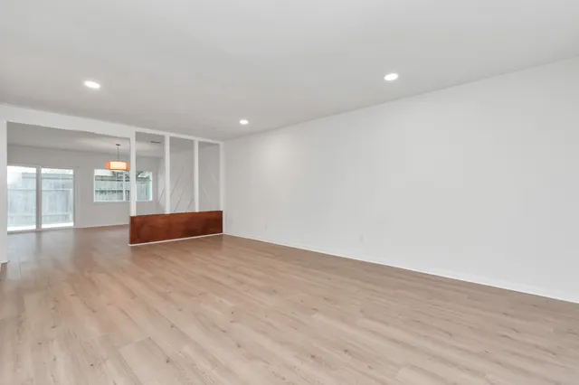 a view of empty room with wooden floor