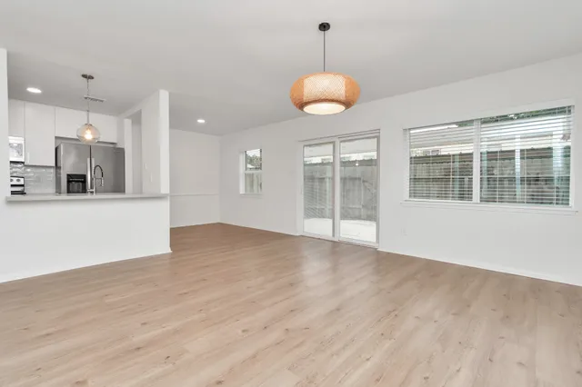 a view of a kitchen with wooden floor and a window