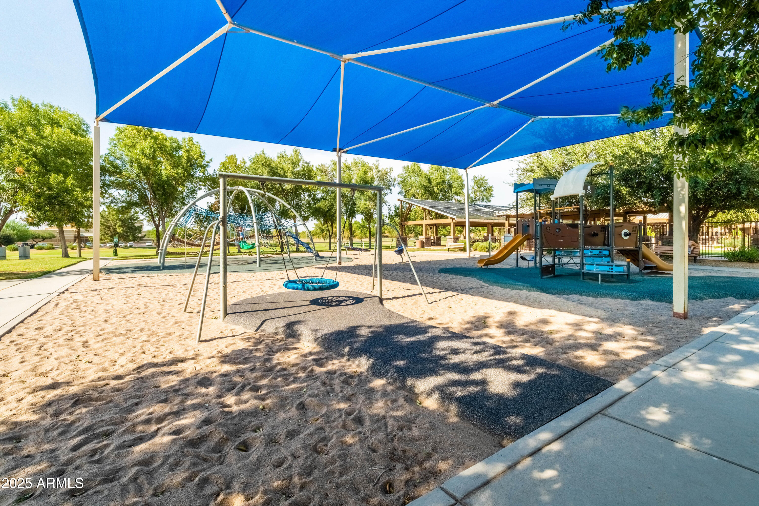 4140 East Claxton Avenue Gilbert, AZ 85297 - Photo 109 of 112 a view of a road with lawn chairs under an umbrella