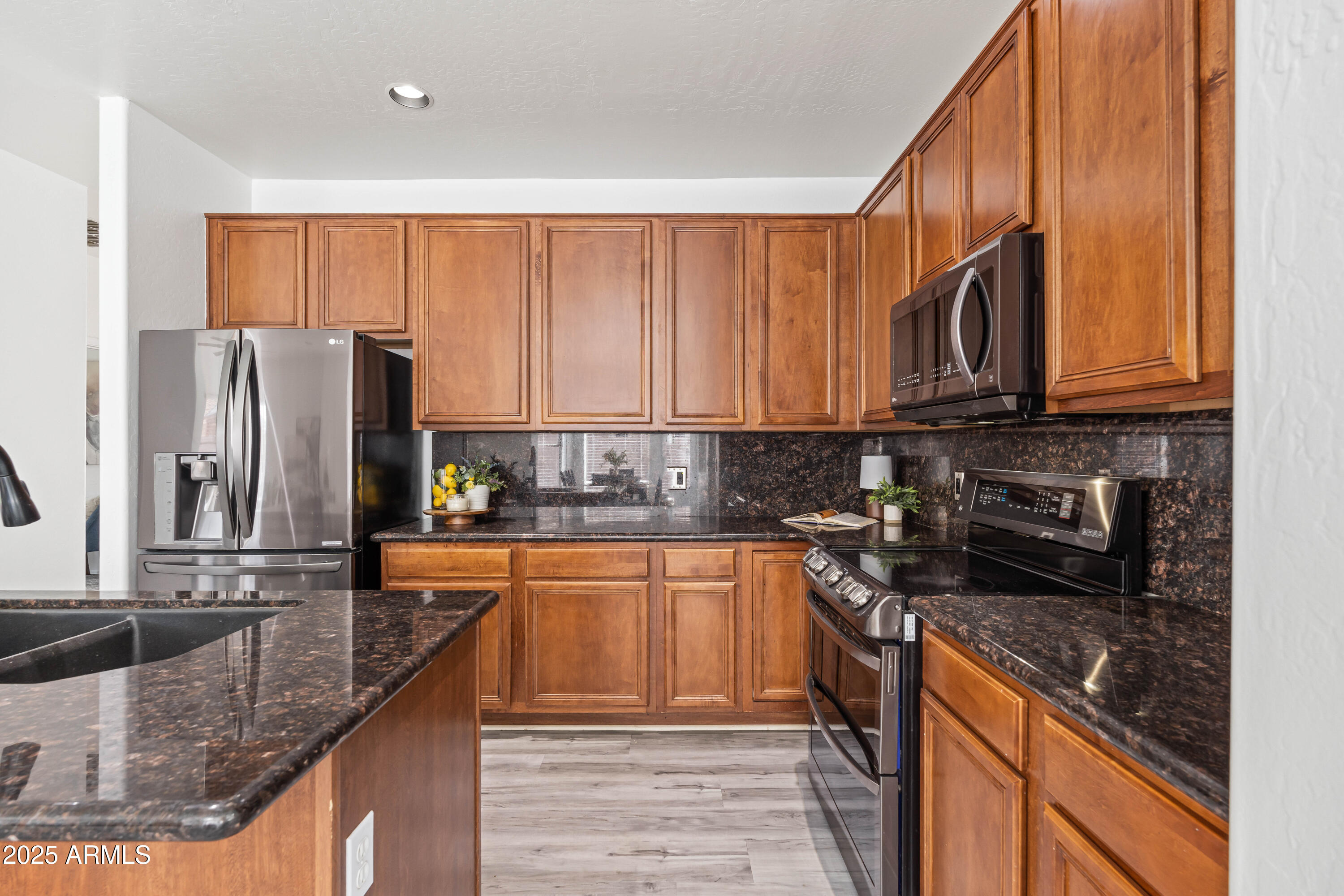 4140 East Claxton Avenue Gilbert, AZ 85297 - Photo 26 of 112 a kitchen with stainless steel appliances granite countertop a refrigerator a stove and a sink with wooden cabinets