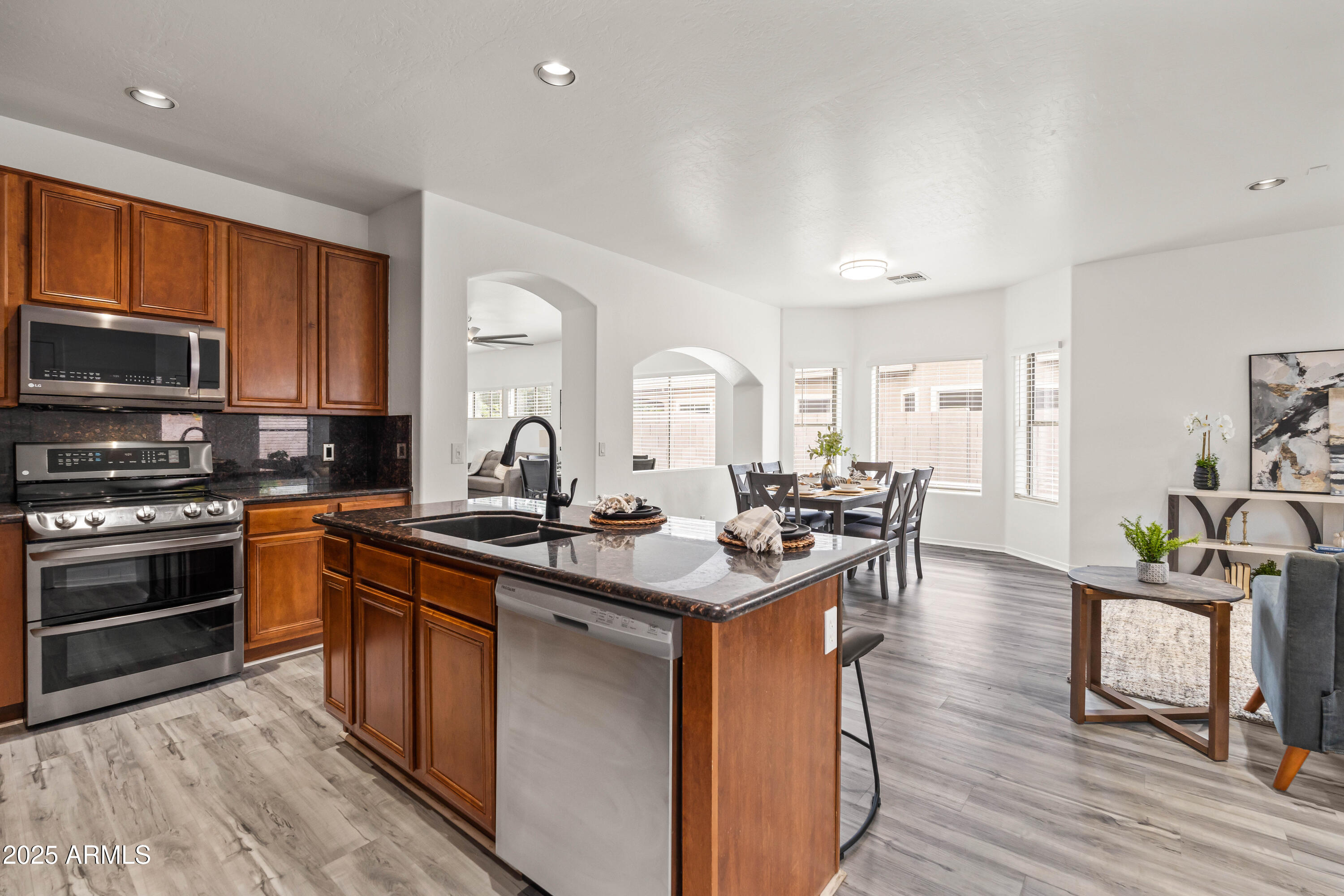 4140 East Claxton Avenue Gilbert, AZ 85297 - Photo 27 of 112 a kitchen with stainless steel appliances granite countertop a stove top oven a sink dishwasher and cabinets with wooden floor
