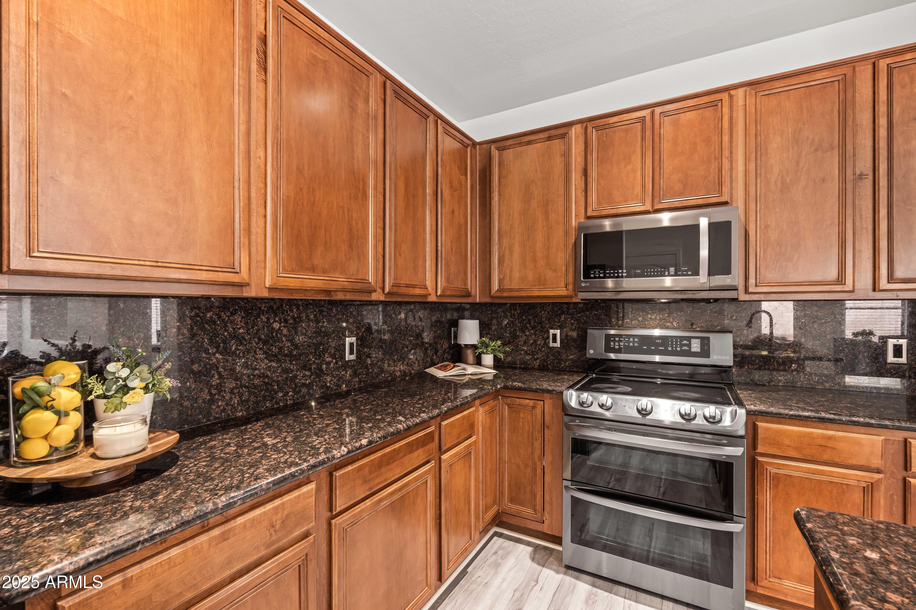 4140 East Claxton Avenue Gilbert, AZ 85297 - Photo 28 of 112 a kitchen with stainless steel appliances granite countertop a stove a sink and a microwave