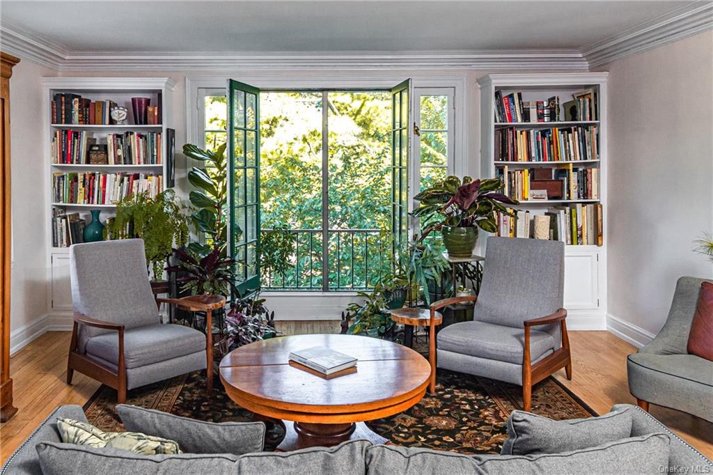 a living room with furniture a bookshelf and a potted plant