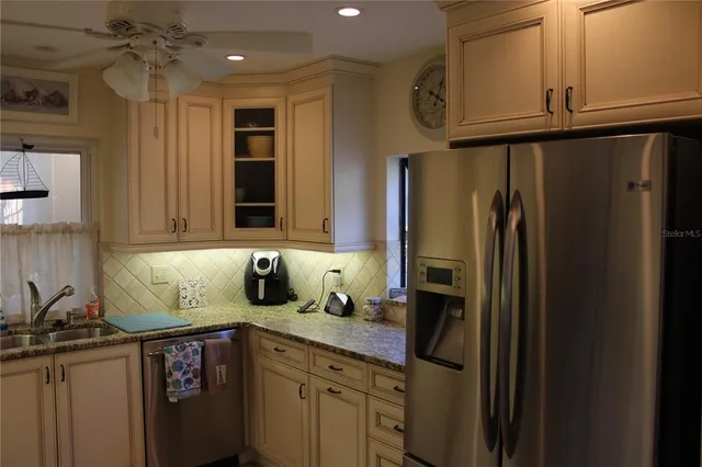 a kitchen with stainless steel appliances granite countertop a refrigerator and a sink