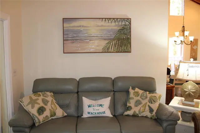 a blue couch sitting next to a lamp on a dresser and a window