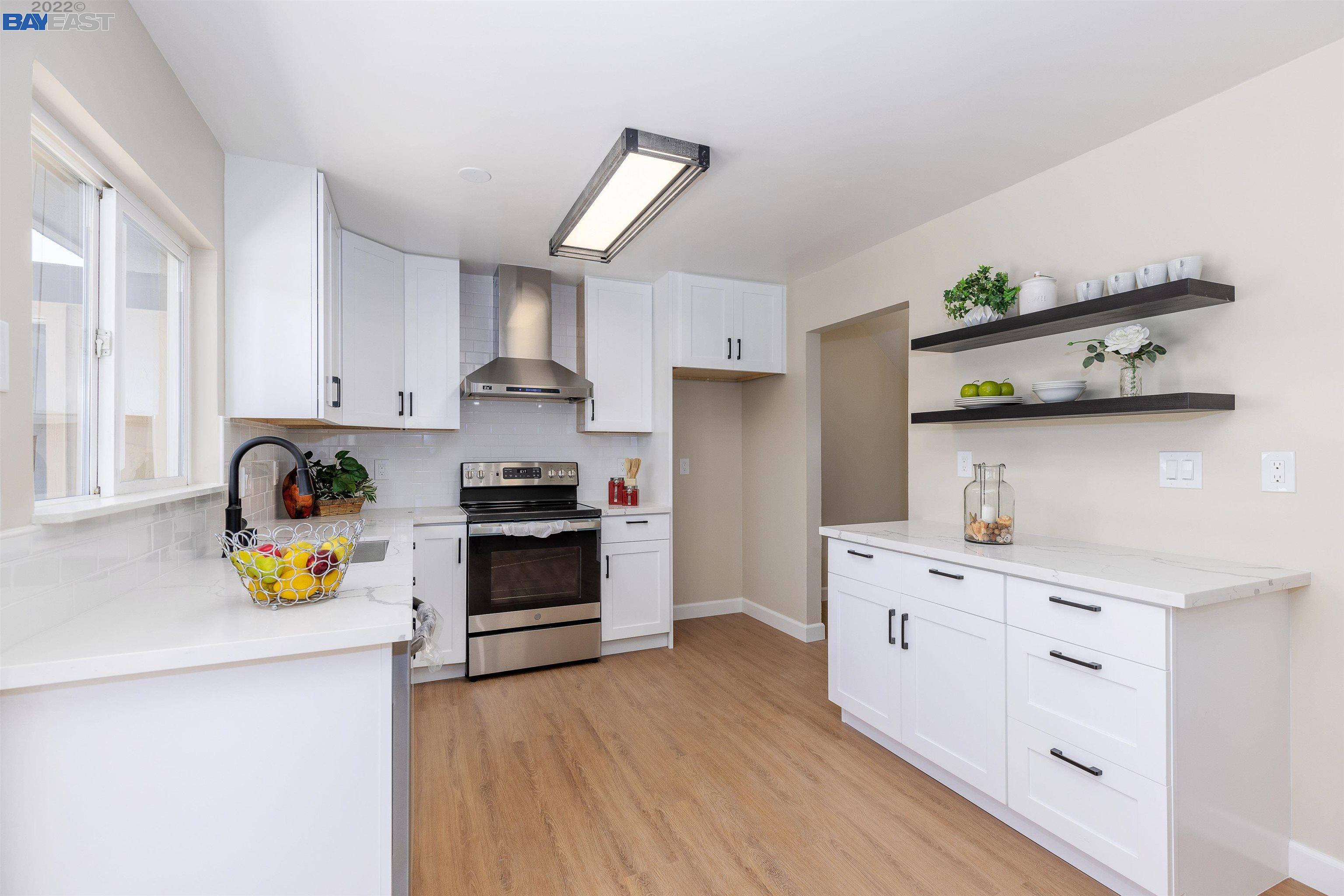a kitchen with stainless steel appliances a stove a sink wooden floor and cabinets