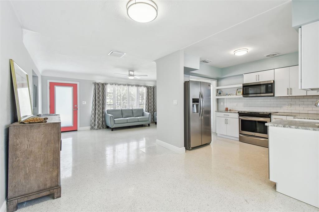 827 Virginia Street Dunedin, FL 34698 - Photo 11 of 46 a living room with stainless steel appliances furniture a flat screen tv and kitchen view