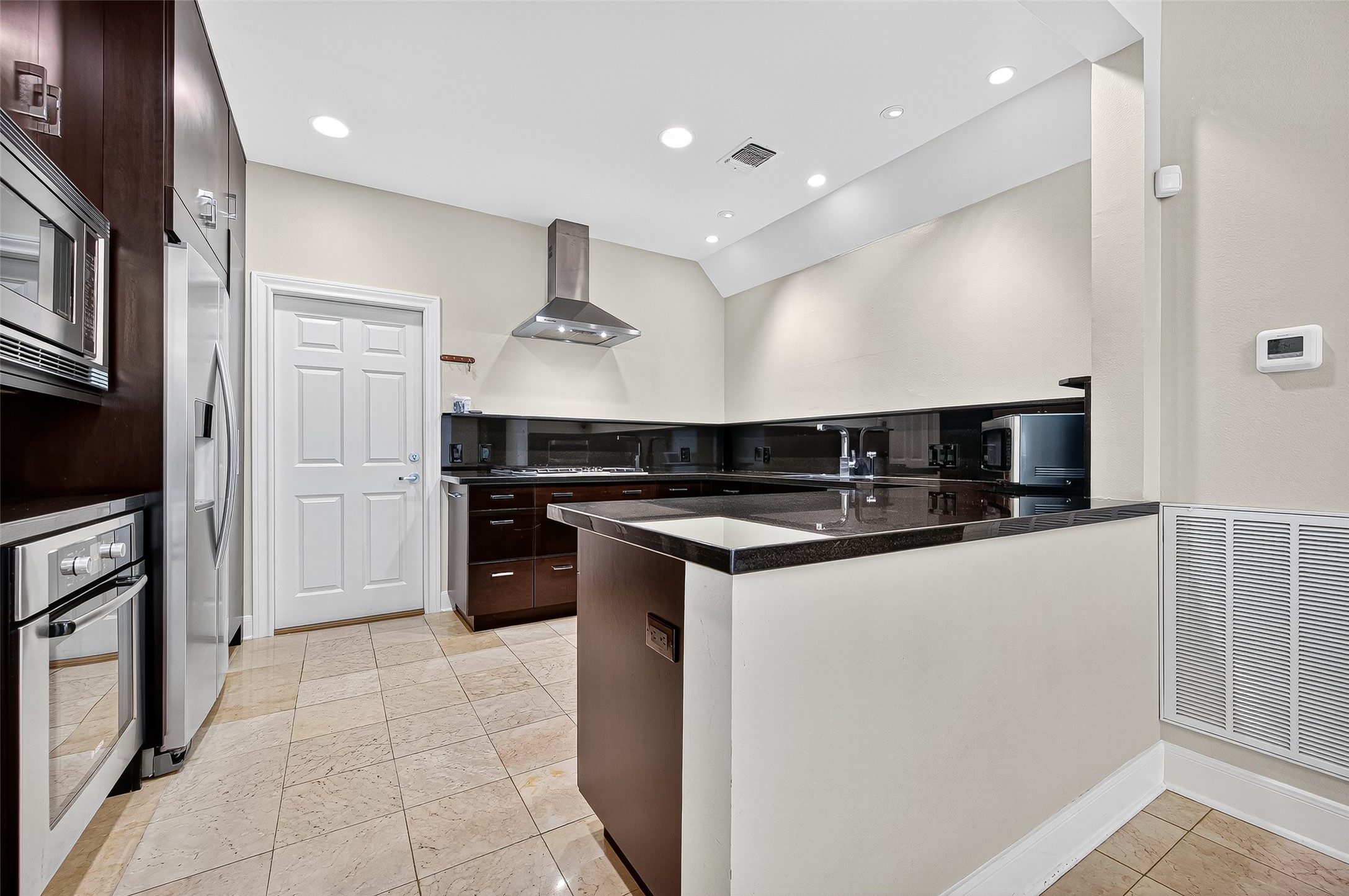 3027 Bissonnet Street Houston, TX 77005 - Photo 15 of 47 Kitchen with island, range hood, and stainless appliances — a serious cooking space
