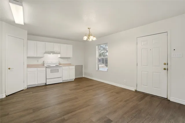 a view of a kitchen with a sink cabinets and wooden floor