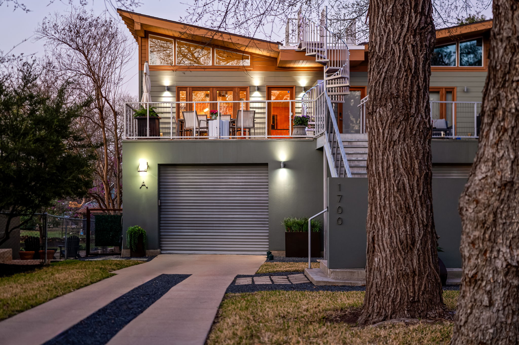 1700 Ravey Street, Unit A Austin, TX 78704 - Photo 5 of 40 View of front of home featuring a garage, concrete driveway, a balcony, and stucco siding