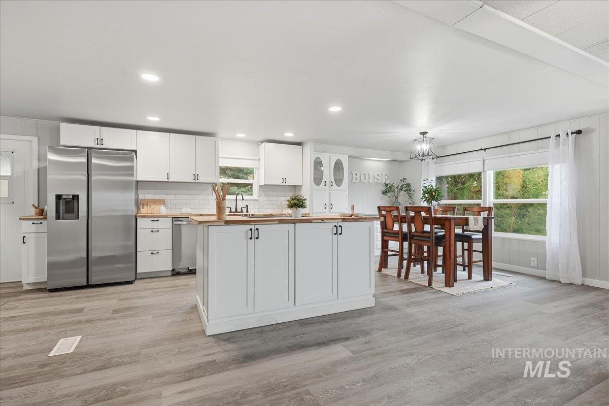 Kitchen featuring white cabinetry, stainless steel appliances, and light wood-style floors