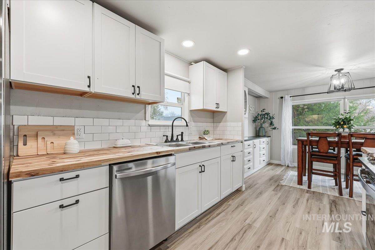 445 South Maple Grove Road, Unit 15 Boise, ID 83709 - Photo 6 of 20 Kitchen featuring appliances with stainless steel finishes, white cabinetry, butcher block countertops, light wood-style flooring, and recessed lighting