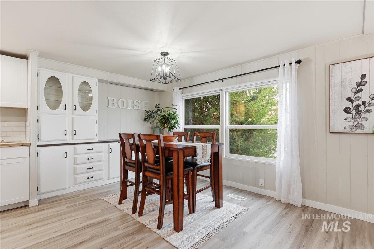 445 South Maple Grove Road, Unit 15 Boise, ID 83709 - Photo 8 of 20 Dining area with light wood-style floors and wood walls