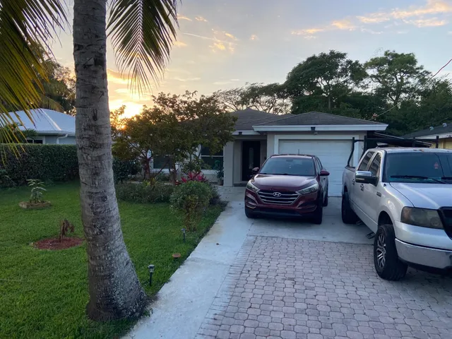 a car parked in front of a house with a garden