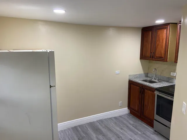 a kitchen with stainless steel appliances granite countertop a sink and wooden cabinets