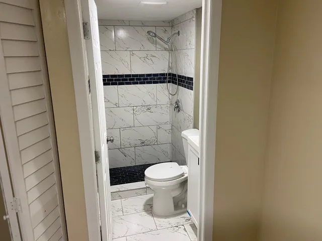 a bathroom with a granite countertop shower and a toilet