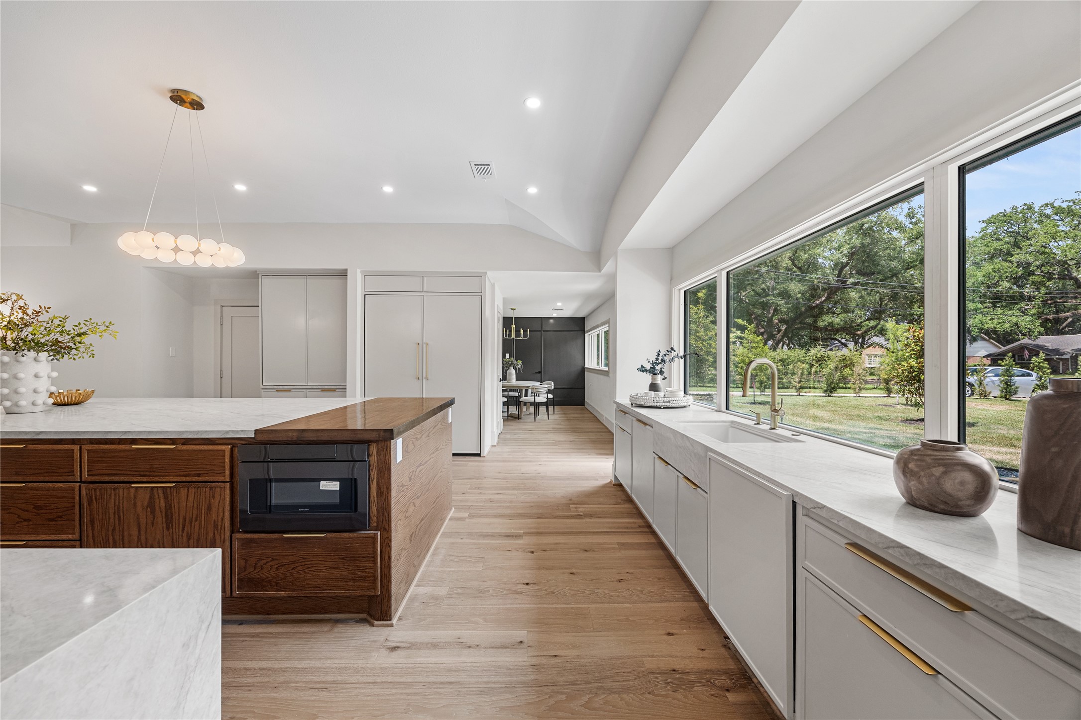 5642 Pine Forest Road Houston, TX 77056 - Photo 21 of 32 Natural light floods every corner of the kitchen through walls of oversized windows, creating a bright and inviting space where beautiful finishes and timeless design take center stage.