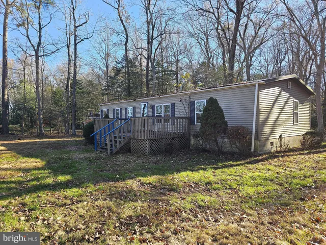 a view of a house with backyard and trees