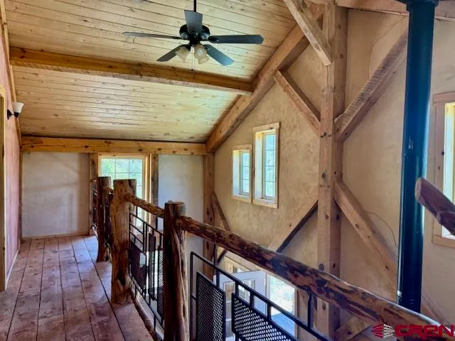a living room with chairs and a dining table with wooden floor