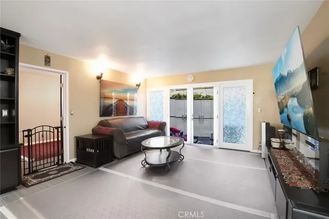 a living room with furniture a flat screen tv and a large window