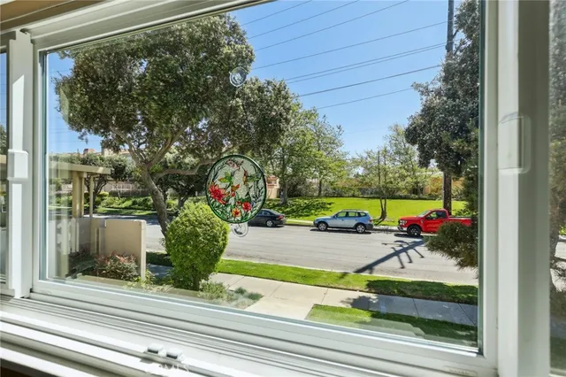 a view of a porch with a floor to ceiling window and potted plants
