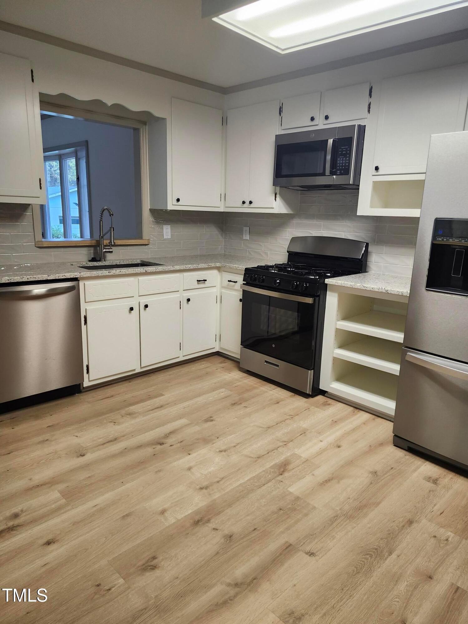 2546 Ardsley Drive Durham, NC 27704 - Photo 11 of 11 a kitchen with stainless steel appliances kitchen island granite countertop a stove and a sink