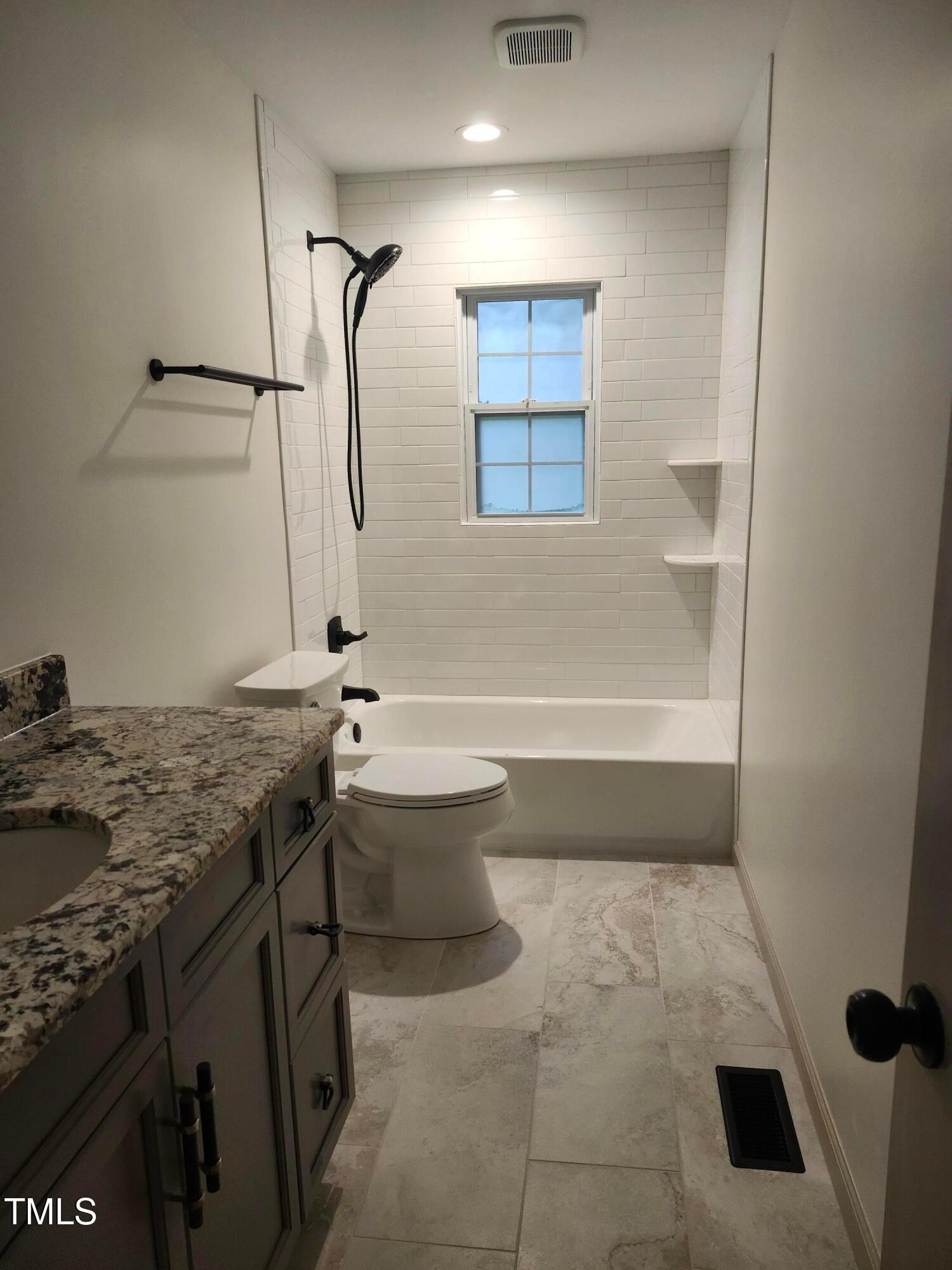 2546 Ardsley Drive Durham, NC 27704 - Photo 3 of 11 a bathroom with a granite countertop sink a toilet and shower