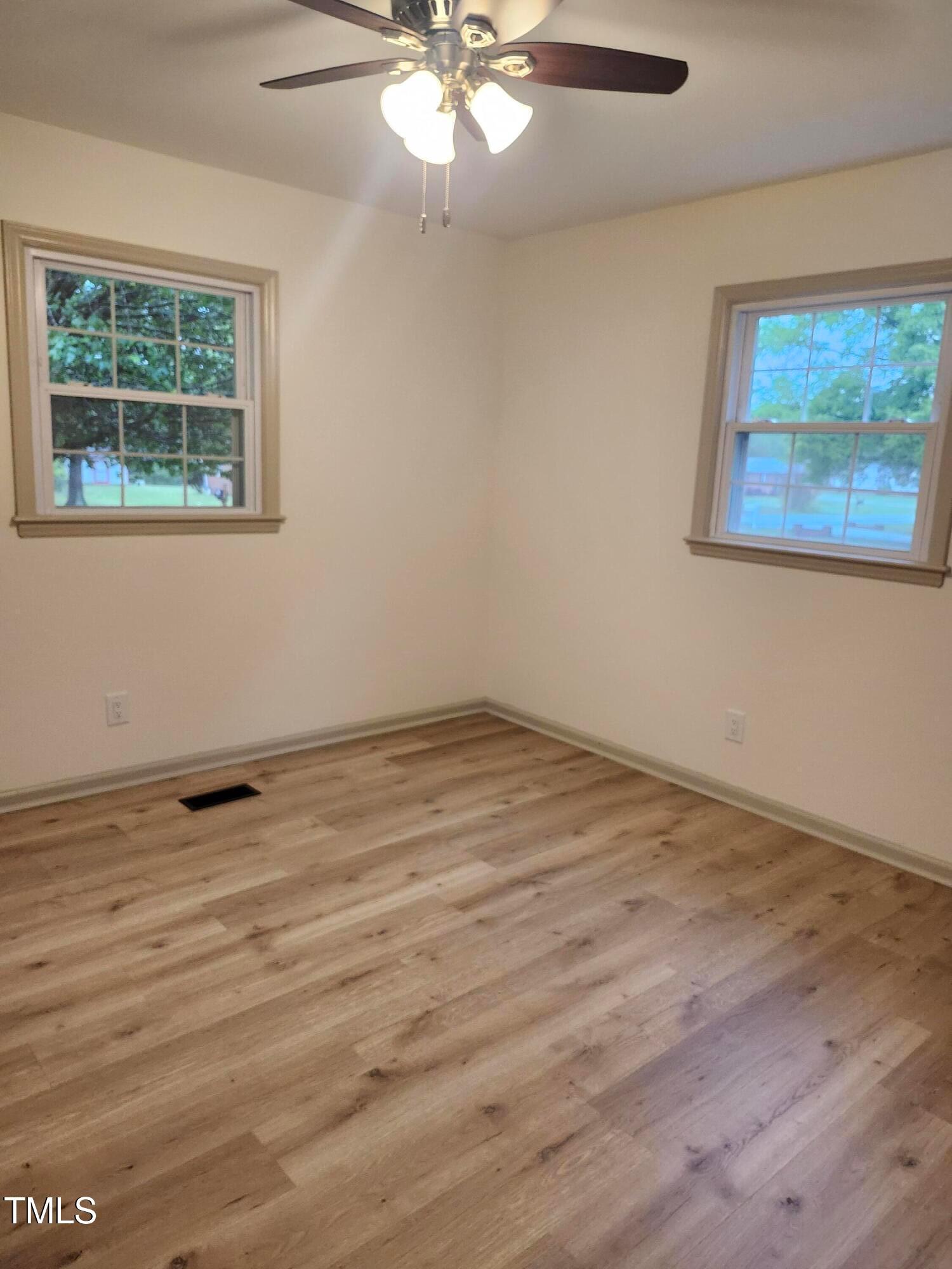 2546 Ardsley Drive Durham, NC 27704 - Photo 7 of 11 a view of an empty room with wooden floor and a window