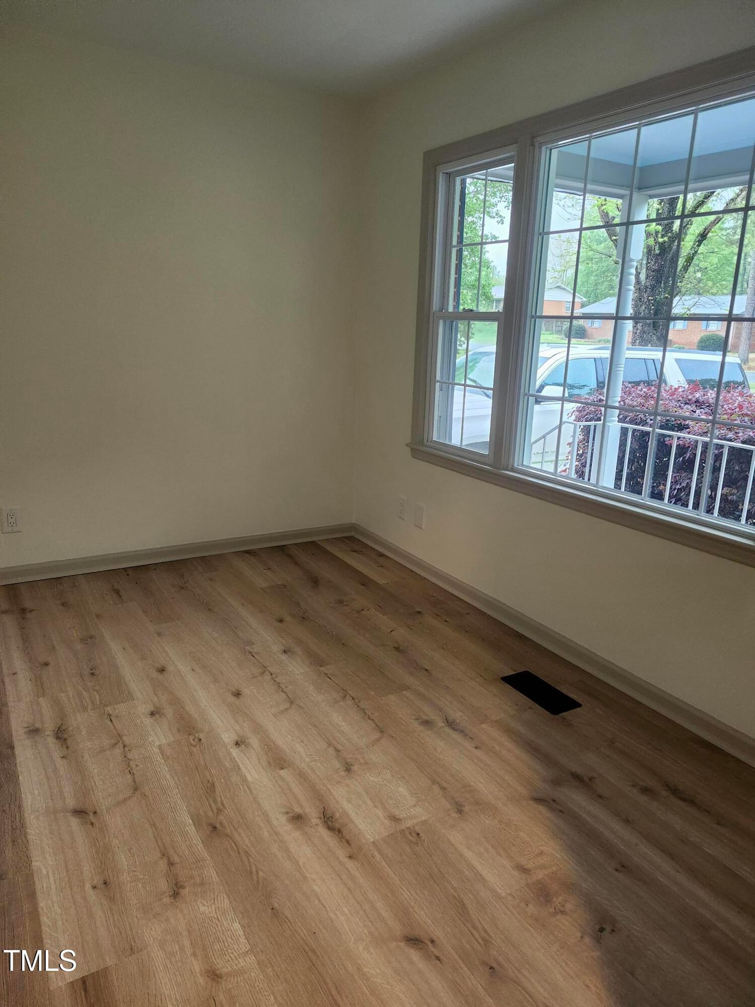2546 Ardsley Drive Durham, NC 27704 - Photo 8 of 11 an empty room with wooden floor and windows