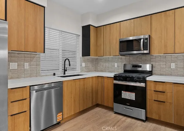 a kitchen with stainless steel appliances granite countertop a stove microwave and sink