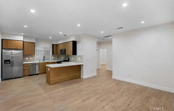a large kitchen with a large counter top appliances and cabinets