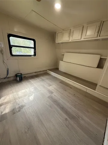 a view of a room with wooden floor and window