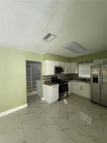 a large kitchen with a large counter top appliances and cabinets