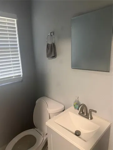 a bathroom with a toilet sink and mirror