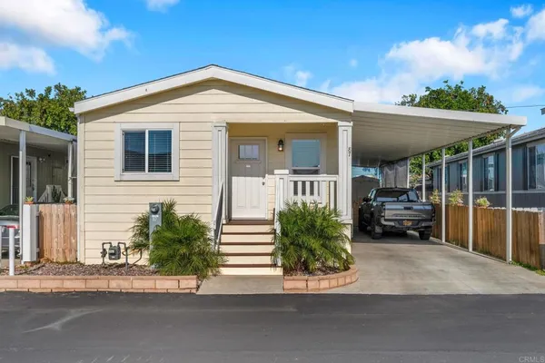 a view of a house with a patio and a yard