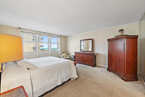 a spacious bedroom with a bed and a dresser