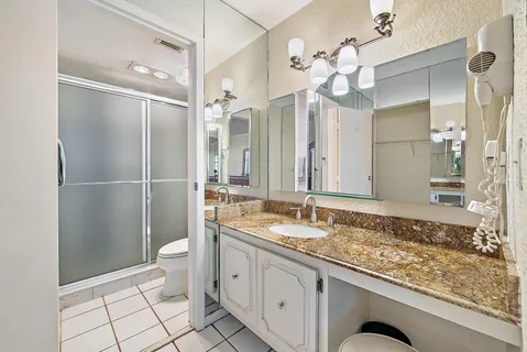 a bathroom with a granite countertop sink mirror and shower