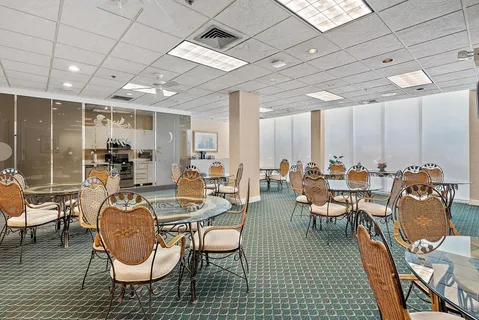 a room with lots of chairs a desk and a chandelier