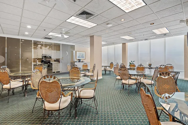 a room with lots of chairs a desk and a chandelier