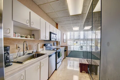 a kitchen with stainless steel appliances granite countertop a stove a sink and white cabinets