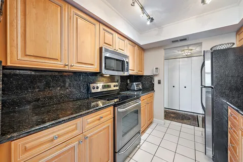 a kitchen with stainless steel appliances granite countertop a refrigerator sink and cabinets