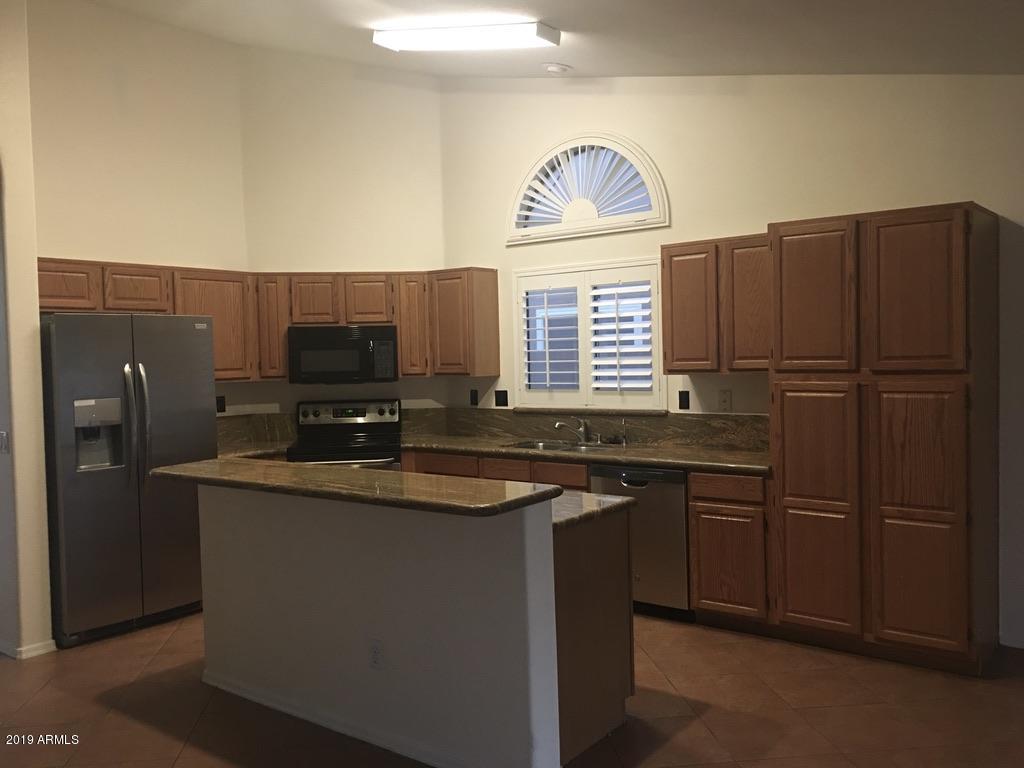 844 North Granite Street Gilbert, AZ 85234 - Photo 3 of 12 a kitchen with stainless steel appliances granite countertop a sink stove and refrigerator