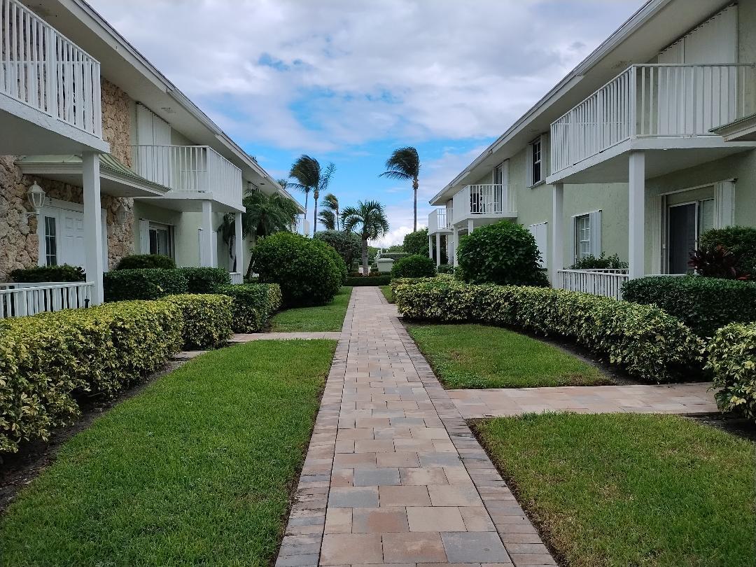5500 Old Ocean Boulevard, Unit 104 Ocean Ridge, FL 33435 - Photo 1 of 19 a view of a white house next to a yard