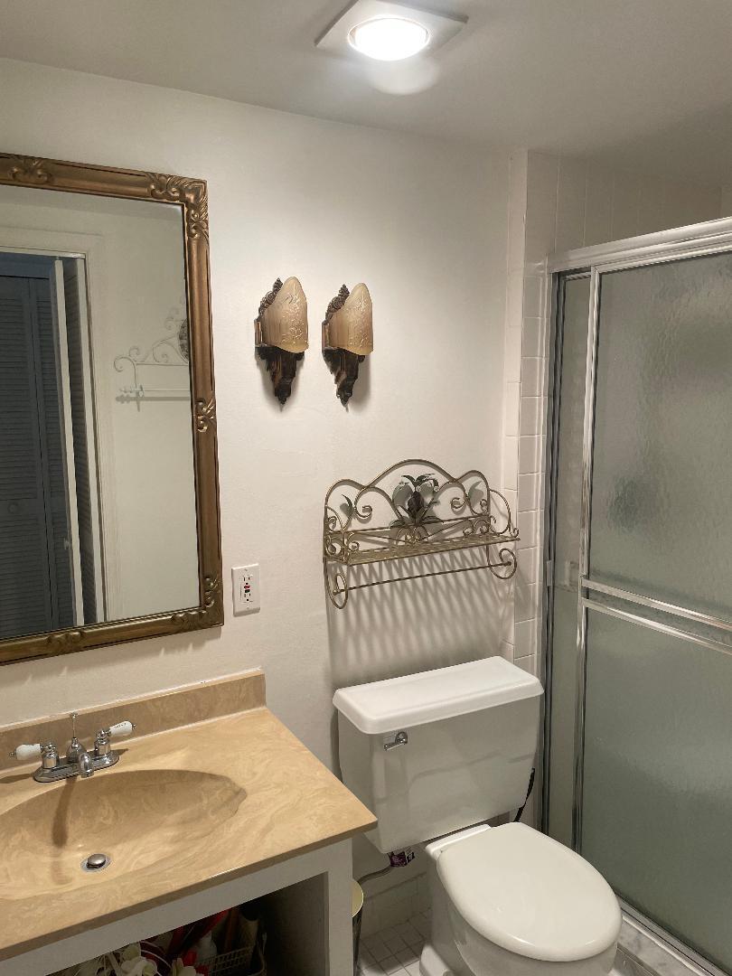 5500 Old Ocean Boulevard, Unit 104 Ocean Ridge, FL 33435 - Photo 13 of 19 a bathroom with a sink a toilet a mirror and shower