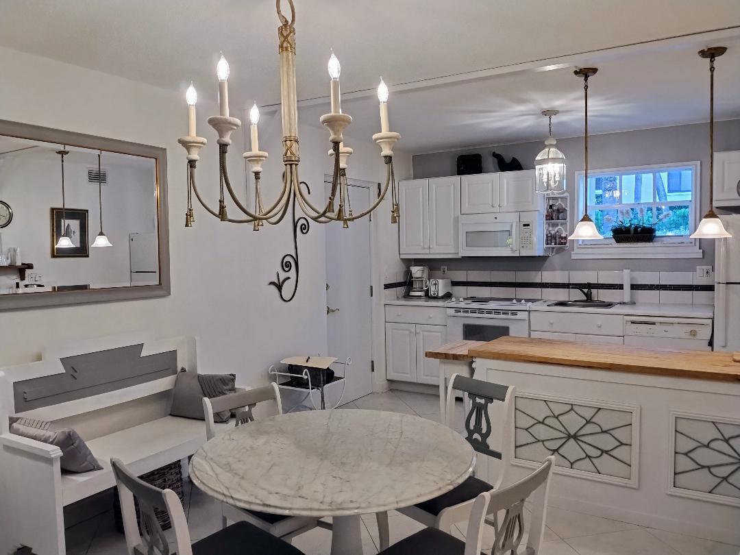 5500 Old Ocean Boulevard, Unit 104 Ocean Ridge, FL 33435 - Photo 17 of 19 a kitchen with stainless steel appliances granite countertop a sink a stove a dining table and chairs
