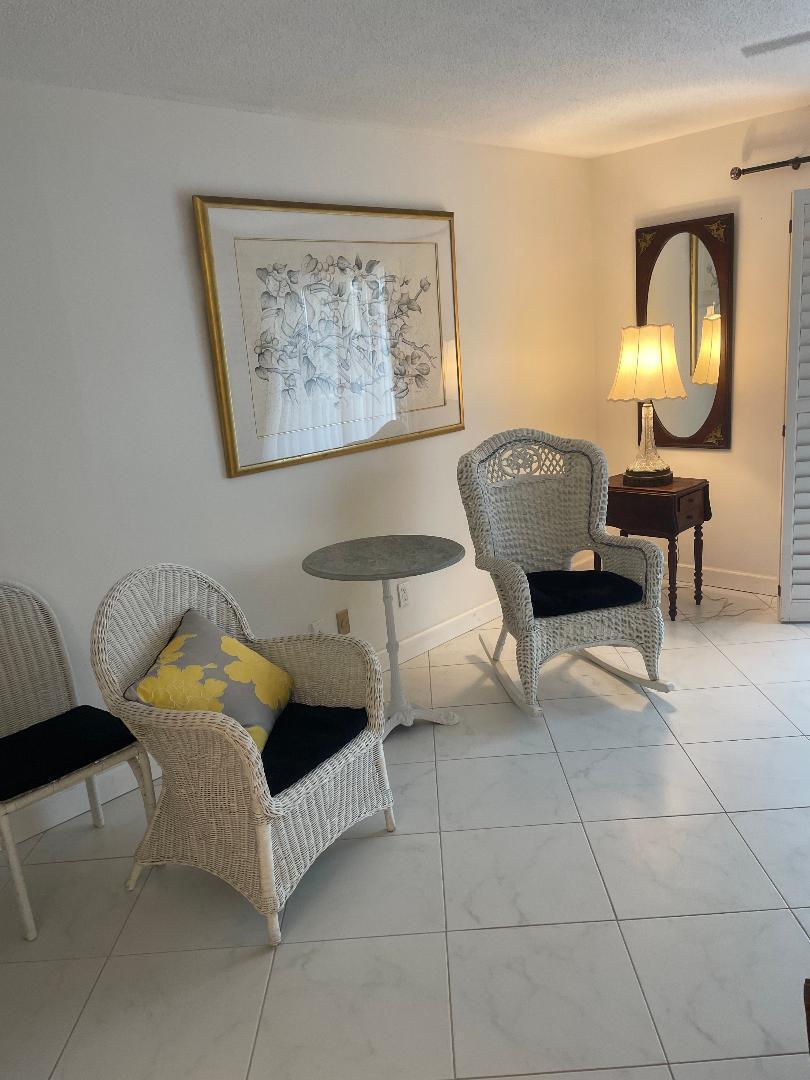 5500 Old Ocean Boulevard, Unit 104 Ocean Ridge, FL 33435 - Photo 6 of 19 a living room with furniture and a mirror