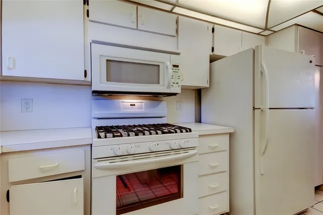 a kitchen with stainless steel appliances white cabinets and a stove top oven
