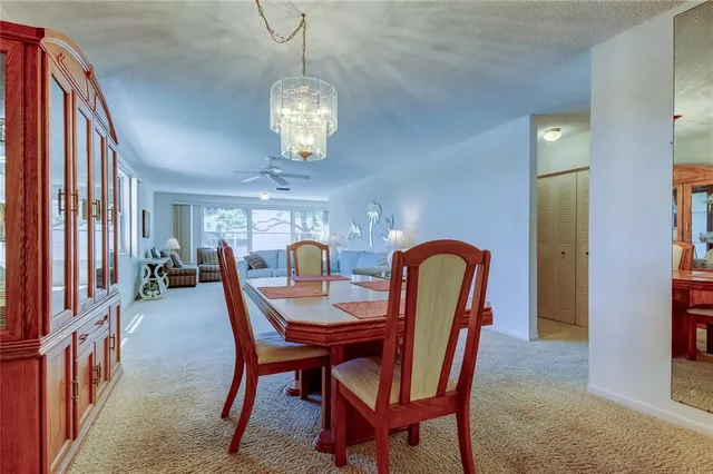 a dining room with furniture a chandelier and wooden floor